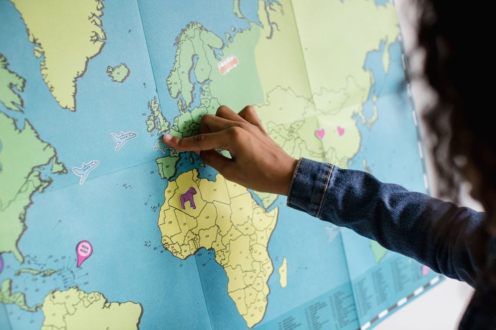 Estudiar inglés Australia chica señalando un mapa del mundo