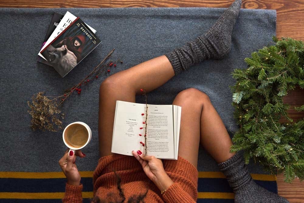 Diferencias TOEFL y IELTS fotografía en picado de una chica con un café y un libro