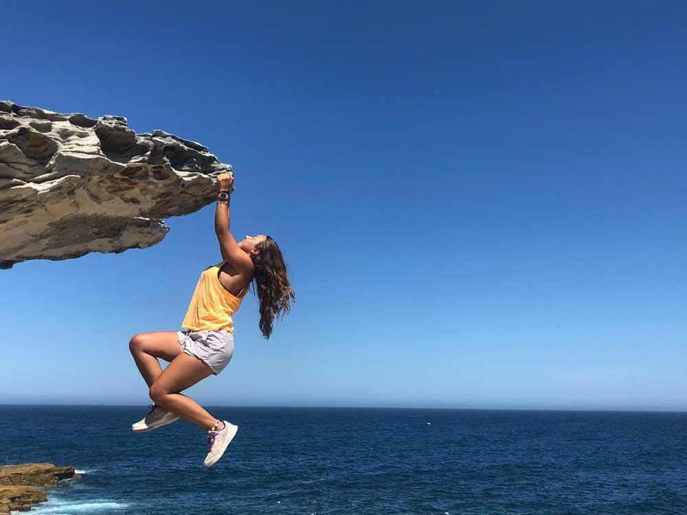 Chica cogida de una piedra