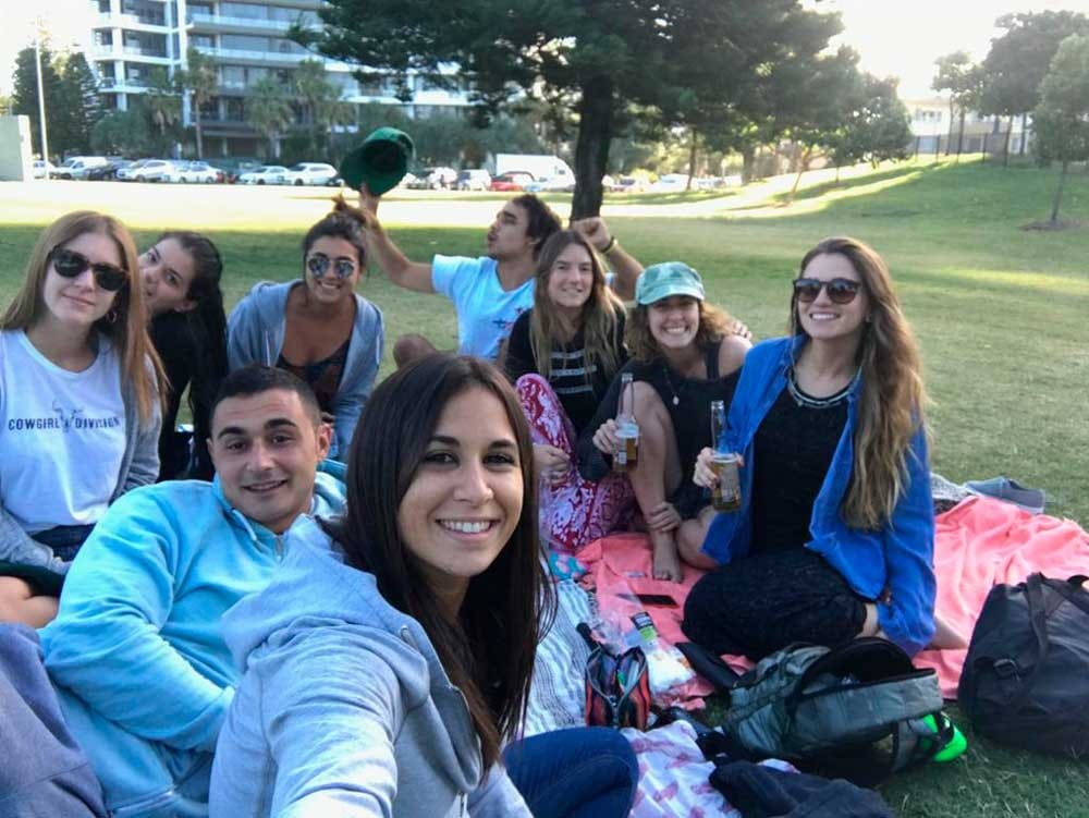 grupo de amigos sentados en el césped y riendo