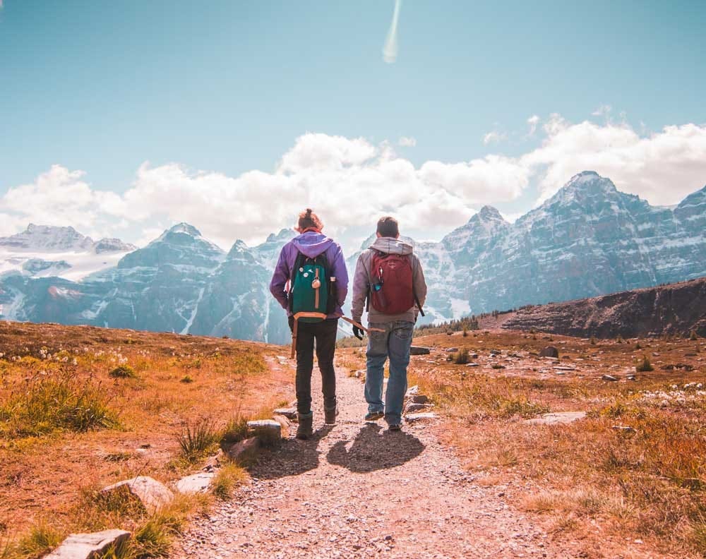 visa nueva zelanda dos estudiantes de espaldas andando por la montaña