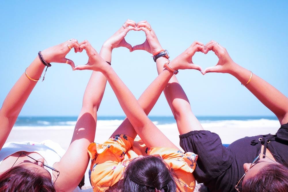 recomendaciones para viajar Tres chicas en la playa haciendo corazones