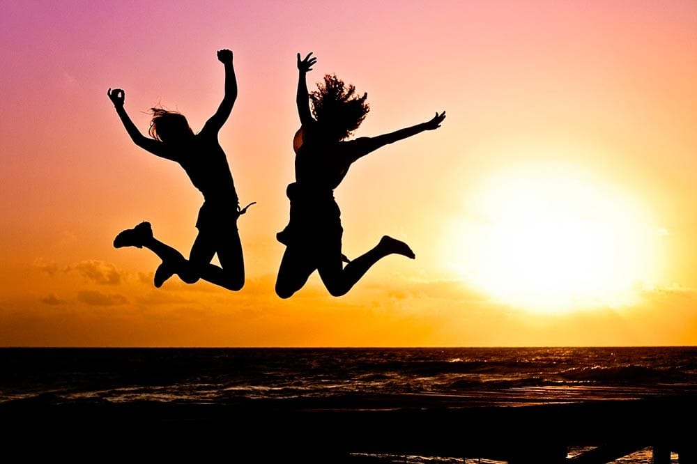 recomendaciones para viajar chicas saltando en el atardecer